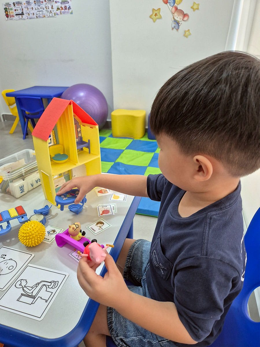 Niño realizando actividades de motricidad fina con juguetes de madera en terapia ocupacional infantil, Panamá